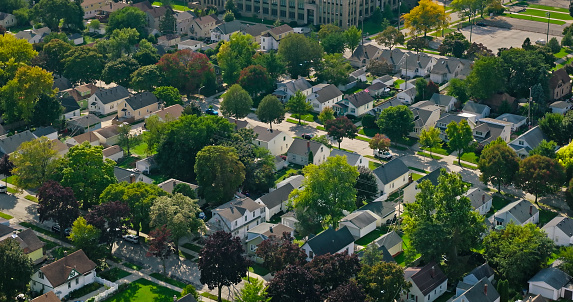 Drone shot of leafy residential streets and single family homes in Bluemound Heights, a neighborhood on the west side of Milwaukee, Wisconsin on a sunny day in Fall.