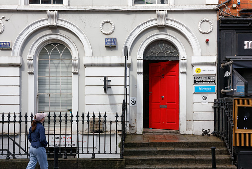 DUBLIN, Ireland - August 5, 2023: Open red door of a historic building on a city street