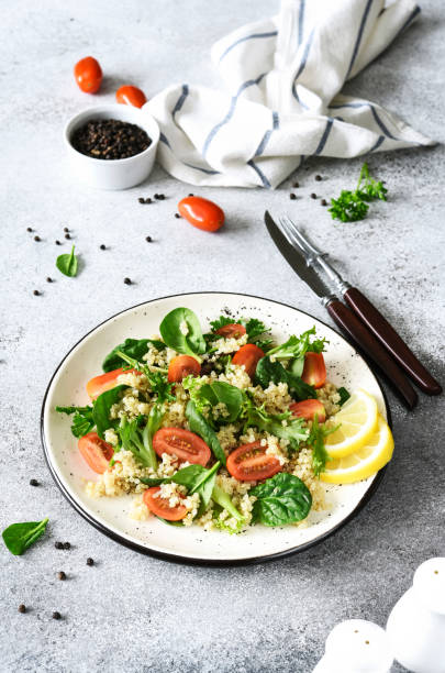 istock Salad with quinoa tomatoes and spinach on a light background 1809937583
