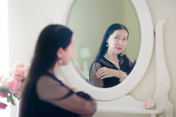 istock Young Asian woman looking in the mirror. 1809940292