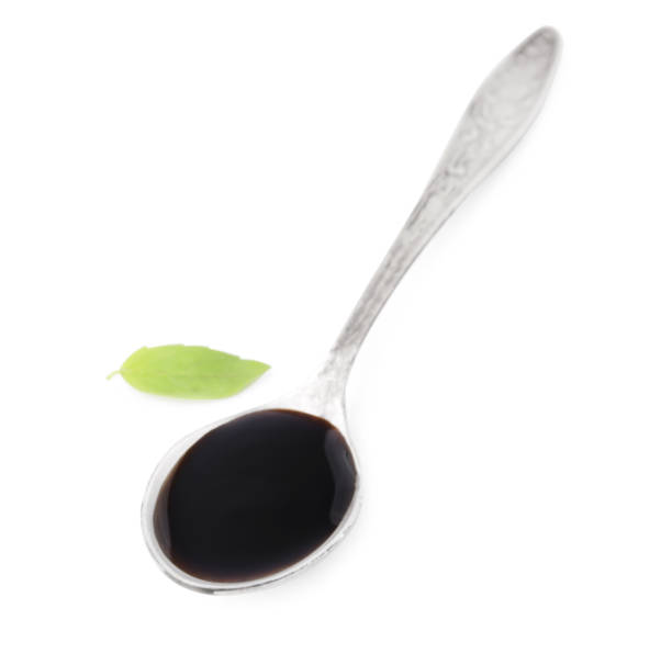 istock Metal spoon with balsamic glaze and basil leaf on white background 1809950672