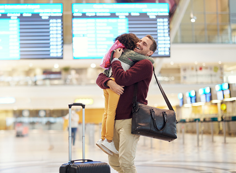 Family, father and child hug at airport, travel and girl greeting man after flight, happiness and love with luggage at terminal. Happy, care and bond with trip, bag and welcome home with reunion