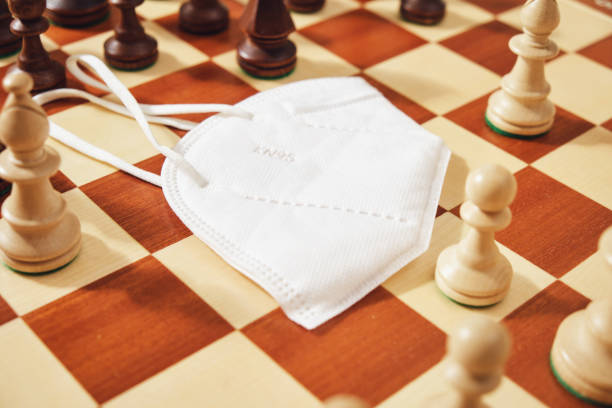 istock Medical face mask with chess pieces on a chessboard 1809953891