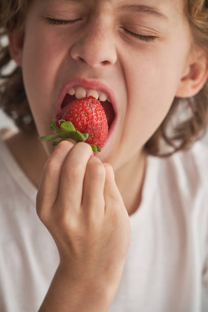 istock Crop positive boy biting strawberry 1809966737