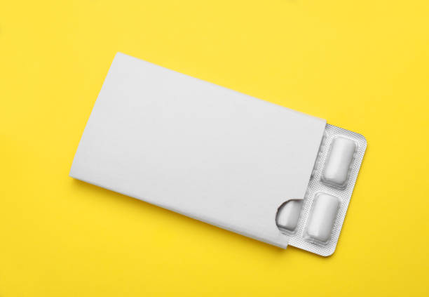 Blister with chewing gums on yellow background, top view