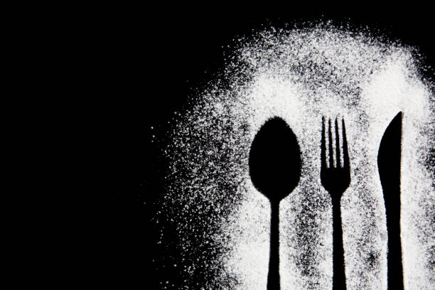 istock Silhouette of a fork spoon and knife drawing with white flour on a black background 1809996008