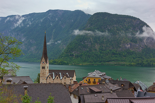 Upper Austria, Hallstatt. A city on the shores of Lake Hallstatt with an evangelical parish church in the center. On the opposite shore of the lake there are beautiful mountains covered with forest.