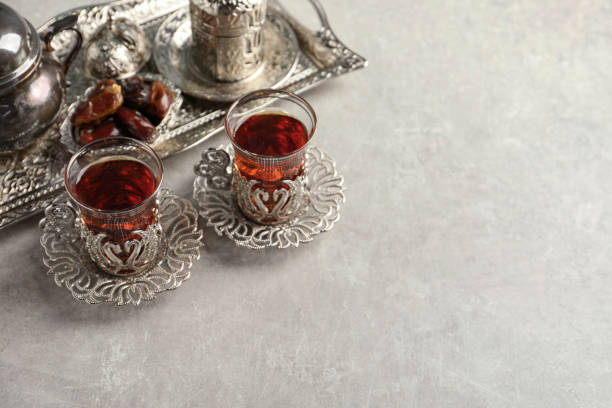 istock Tea and date fruits served in vintage tea set on grey table, space for text 1810009612