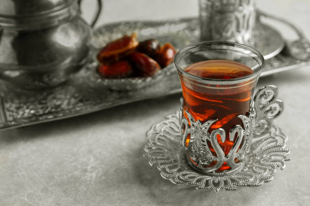 istock Tea and date fruits served in vintage tea set on grey table, space for text 1810009627