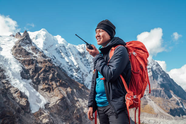 Portrait of Sherpa man with backpack using walkie-talkie for calling rescue helicopter with Mera peak 6476m background.High Himalayas expedition during mount climbing. Traveling, active people concept Portrait of Sherpa man with backpack using walkie-talkie for calling rescue helicopter with Mera peak 6476m background.High Himalayas expedition during mount climbing. Traveling, active people concept transceiver stock pictures, royalty-free photos & images