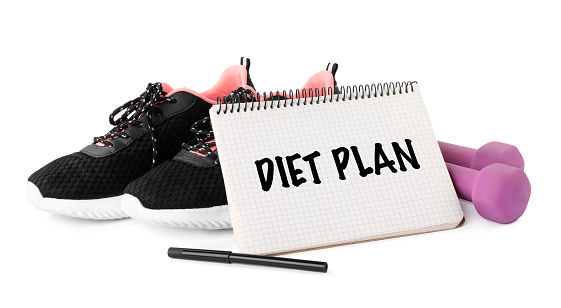 Notebook with phrase Weight Loss Program, sneakers and dumbbells on white background