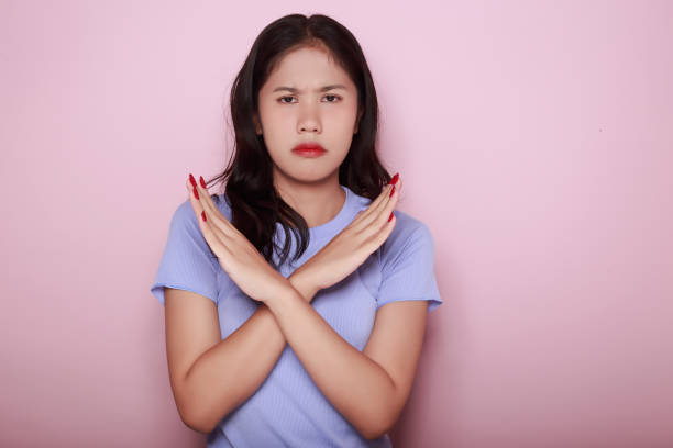 istock Asian woman making a stressed expression Standing alone on a light pink background. Beautiful young woman is feeling stressed. 1810026987