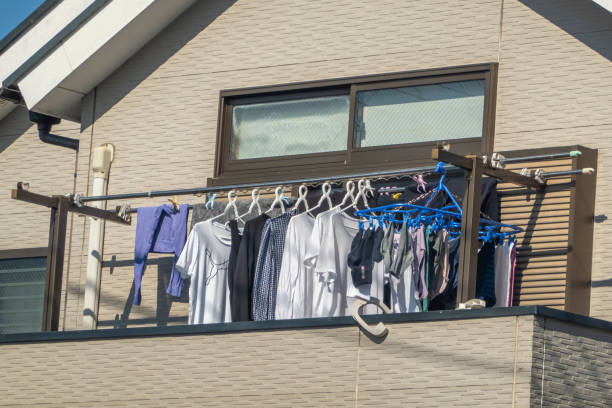Tama New Town, Tokyo, Japan. Nov 20 2023. A residence balcony with hung laundered clothing, with additional damp garments strategically positioned to facilitate the drying process under the sunlight.