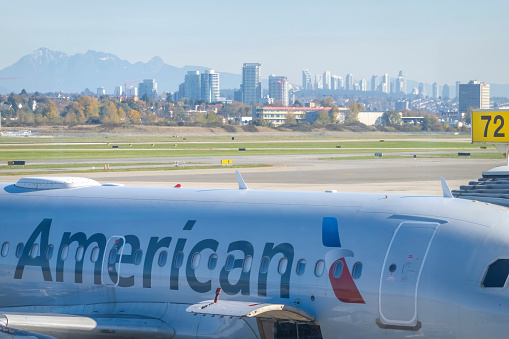 Vancouver, British Columbia, Canada, Nov. 16, 2023. An American Airlines aircraft at the Vancouver International airport, set against the backdrop of Vancouver city.