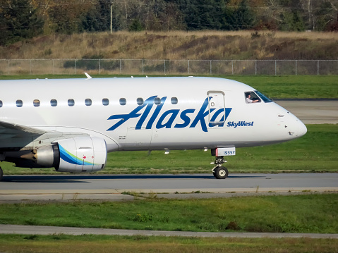 Richmond, BC, Canada. Nov 18, 2023. A detailed shot captures the frontal view of an Alaska Skywest airplane against the backdrop of the fall season.