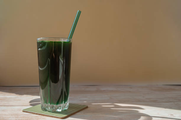 organiczny napój detoksykacyjny z niebiesko-zielonych alg spirulina w szklanym proszku. koktajl proteinowy ze zdrową chlorellą. witaminy i minerały do diety. prebiotyk i przeciwutleniacz bogaty suplement diety wodorosty superfood - chlorofil zdjęcia i obrazy z banku zdjęć