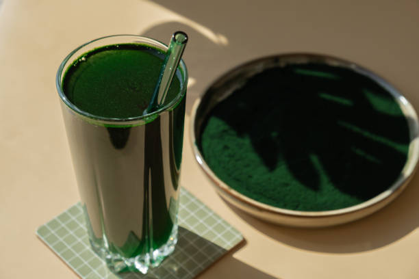 organiczny napój detoksykacyjny z niebiesko-zielonych alg spirulina w szklanym proszku. koktajl proteinowy ze zdrową chlorellą. witaminy i minerały do diety. prebiotyk i przeciwutleniacz bogaty suplement diety wodorosty superfood - chlorofil zdjęcia i obrazy z banku zdjęć