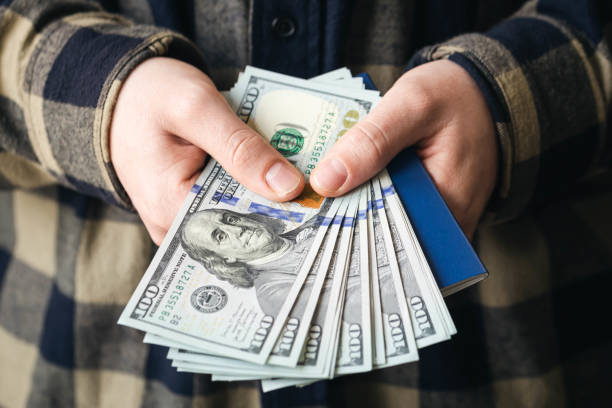 istock Passport and dollar bills in male hands, close-up. 1810051227