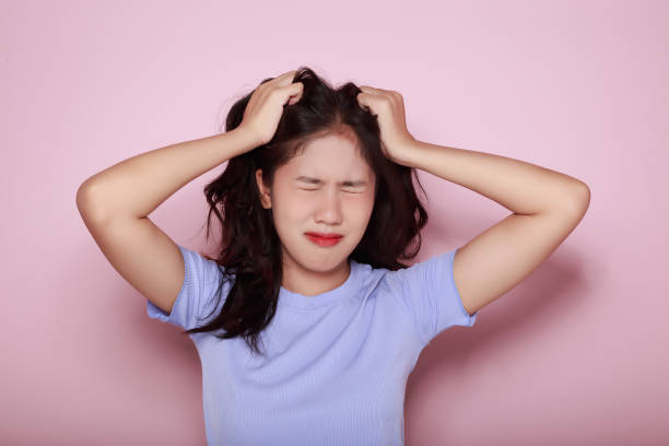 istock Asian woman making a stressed expression Standing alone on a light pink background. Beautiful young woman is feeling stressed. 1810065535