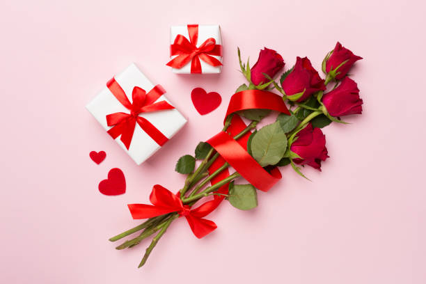 istock Valentines day gift box with red roses on color background, top view 1810078423