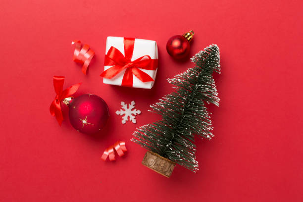 istock Miniature christmas tree with gift box and decor on color background 1810078459