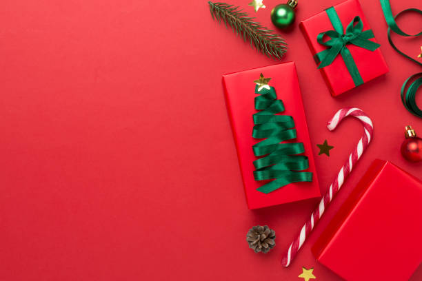 istock Gift boxes with paper's rools and christmas decoration on color background, top view 1810078461