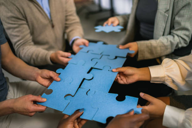 istock Group of professional people playing puzzle in the office. 1810083326
