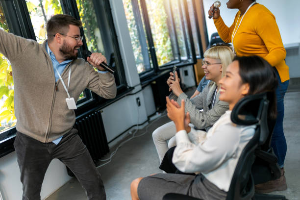 istock Business people making team training exercise during team building seminar singing karaoke 1810083349