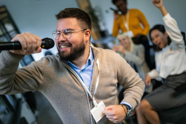 istock Business people making team training exercise during team building seminar singing karaoke 1810083351