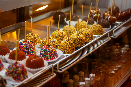 Caramel apples with various toppings arranged on trays