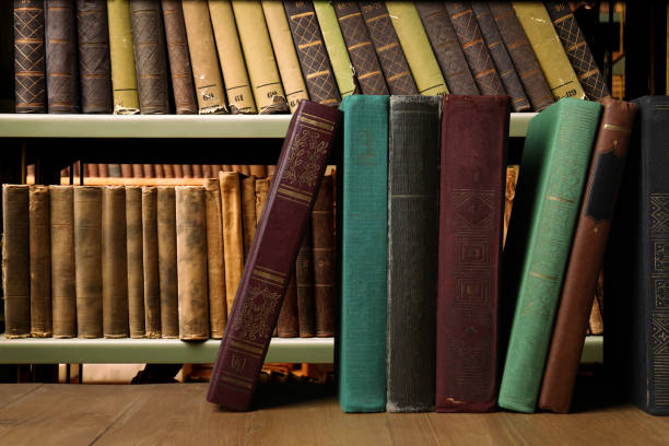 istock Many hardcover books on wooden table in library, space for text 1810099603
