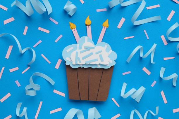 istock Birthday party. Paper cupcake and confetti on light blue background, flat lay 1810099612