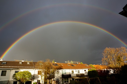 Rainbow over the houses. A beautiful rainbow. Rainbow in Europe. Rainbow after rain. Rainbow in Bad Aibling, Upper Bavaria, Germany.