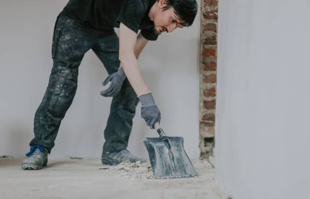 istock A young man collects construction waste with a dustpan. 1810118784