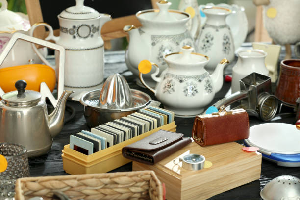 istock Many different stuff on black wooden table. Garage sale 1810121517