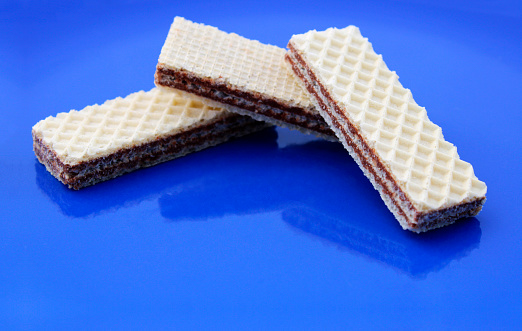 Wafer filled with chocolate cream on blue background