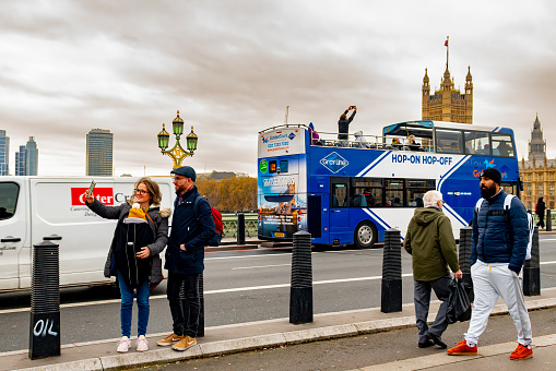 Buses and taxis on Westminster Bridge in front of The Houses of Parliament.  Westminster Bridge, London, UK.