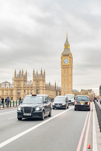 Taxis on Westminster Bridge in front of The Houses of Parliament.  Westminster Bridge, London, UK.