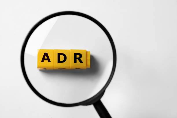 istock Alternative dispute resolution. Top view through magnifying glass on yellow cubes with letters ADR, white background 1810146110