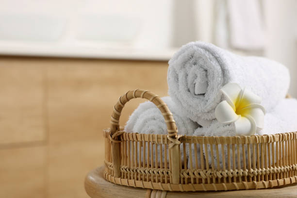 istock Rolled towels on wicker table in bathroom, closeup. Space for text 1810146652