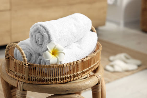 istock Rolled towels on wicker stool in bathroom. Space for text 1810147175