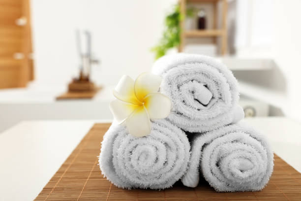 istock Rolled towels on white table in bathroom. Space for text 1810147391