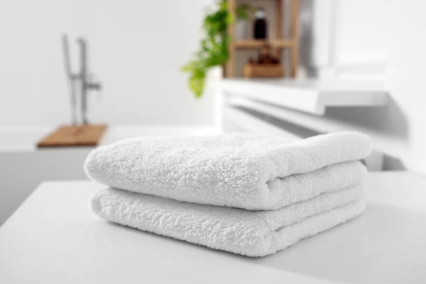 istock Stacked soft towels on white table in bathroom 1810147685