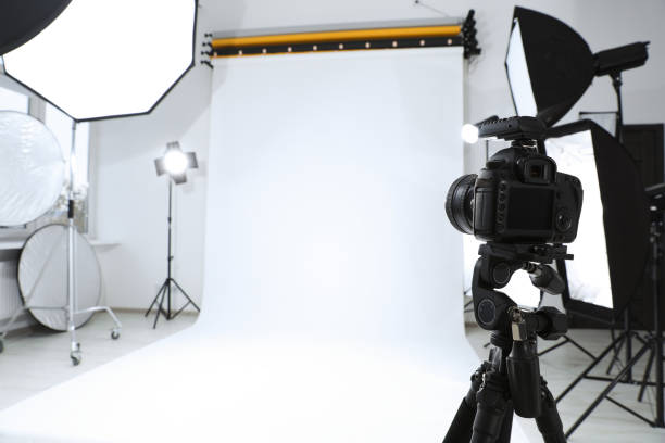 istock Tripod with camera and professional lighting equipment in modern photo studio. Space for text 1810147693