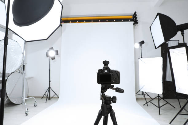 istock Tripod with camera and professional lighting equipment in modern photo studio 1810147697