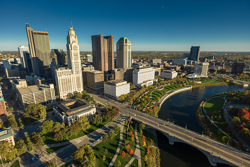 Aerial still image of Downtown Columbus, with Discovery Bridge and East Bank Park, taken by a drone on a clear, Fall day in Ohio.
