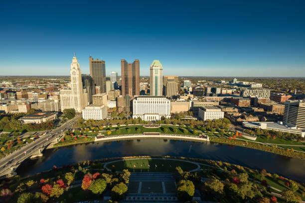 Aerial still image of Downtown Columbus, with Discovery Bridge and East Bank Park, taken by a drone on a clear, Fall day in Ohio.