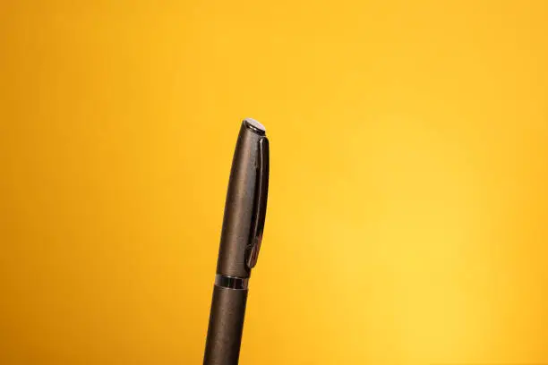 Fountain pen for writing, metal ballpoint pen on a yellow, gold background