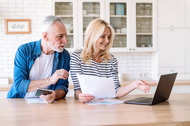 istock Smiling mature couple check and pay utility bills on laptop 1810154199