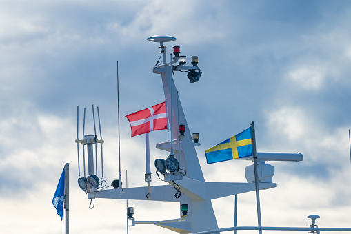 Danish and swedish flags on a top mast of a fishing trawler.